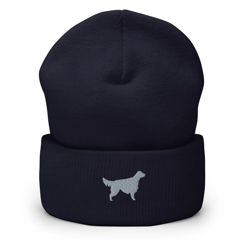 May include: A navy blue beanie with a gray embroidered silhouette of a dog on the front.