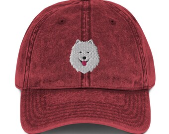 May include: A red vintage washed cotton baseball cap with an embroidered white dog face with a pink tongue.