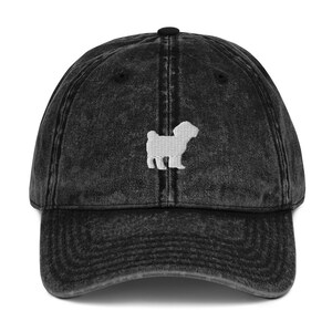 May include: A black vintage washed denim baseball cap with a white embroidered silhouette of a dog.
