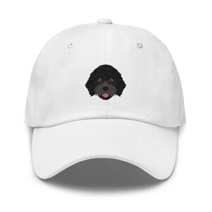 Puede incluir: Gorra de béisbol blanca con un caniche negro bordado con la lengua rosa.