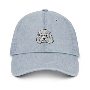 Könnte beinhalten: Eine hellblaue Baseballkappe aus Denim mit einem aufgestickten weißen Pudel auf der Vorderseite.