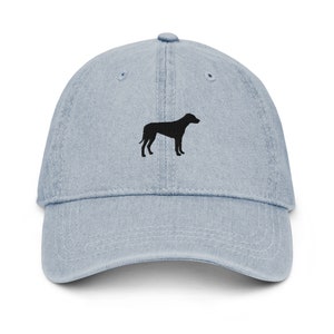 May include: A light blue denim baseball cap with a black silhouette of a dog embroidered on the front.