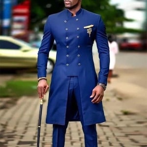 May include: A long, double-breasted, navy blue suit with a mandarin collar and gold-colored embellishments. The suit features a long jacket and matching trousers. The person is holding a black cane with gold accents.