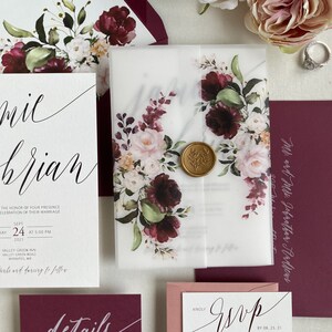 Puede incluir: Un conjunto de invitaciones de boda floral en color burdeos y rubor con un sello de cera. La invitación incluye los nombres "mil brian", la fecha "Sept 24 2021" y la hora "5:00 PM". La tarjeta RSVP incluye el texto "RSVP antes del 08.25.21" y la opción de "aceptar con gusto".