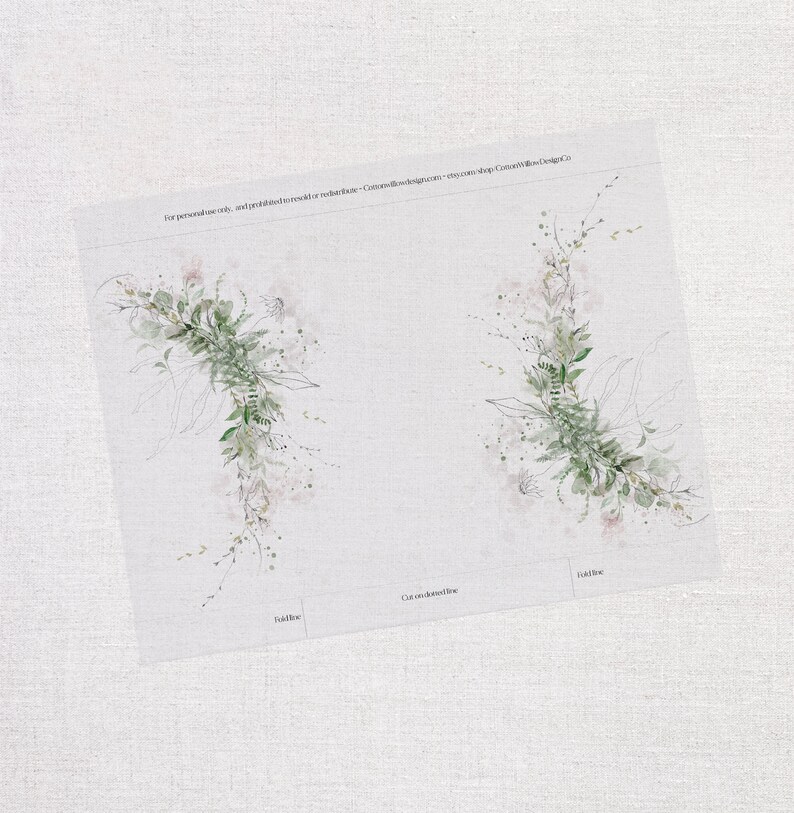 Op de afbeelding: Twee aquarel illustraties van groene, bladerige bloemkransen met delicate roze accenten. De kransen bevinden zich op een witte achtergrond met de tekst "Knip op de gestippelde lijn" en "Vouwlijn" eronder.