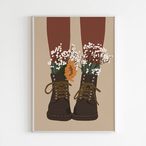 May include: A pair of brown leather boots with laces, each with a bouquet of white flowers and a single orange flower tucked inside.