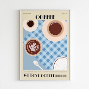 May include: A framed art print featuring a coffee-themed design. The artwork showcases various coffee cups and a spoon on a blue checkered tablecloth. The words "COFFEE" and "WE LOVE COFFEE" are prominently displayed.