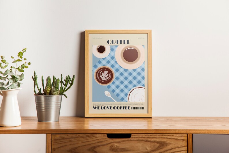 May include: A framed art print featuring coffee cups and a latte on a blue checkered background. The word "COFFEE" is at the top, and "WE LOVE COFFEE" is at the bottom. The print is displayed on a wooden surface.