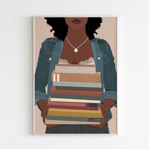 May include: A woman with curly black hair is wearing a blue denim jacket and holding a stack of books in front of her chest. The books are various colors and sizes.