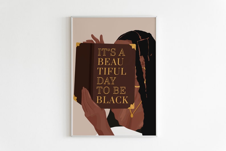 May include: A woman with long black hair holds a book in front of her face. The book is brown with gold lettering that reads "It's a beautiful day to be black."