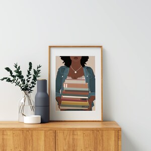May include: A framed illustration of a person with dark brown curly hair wearing a blue denim jacket and holding a stack of colorful books in front of their chest.