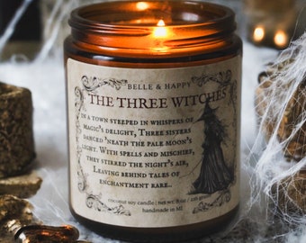 Puede incluir: Un tarro de vela de vidrio marrón con una etiqueta blanca que dice "BELLE & HAPPY THE THREE WITCHES" y una descripción de tres brujas en un pueblo empapado de susurros de delicias mágicas. La vela es una vela de soja de coco con un peso neto de 8 onzas o 236 gramos. Está hecha a mano en Michigan.