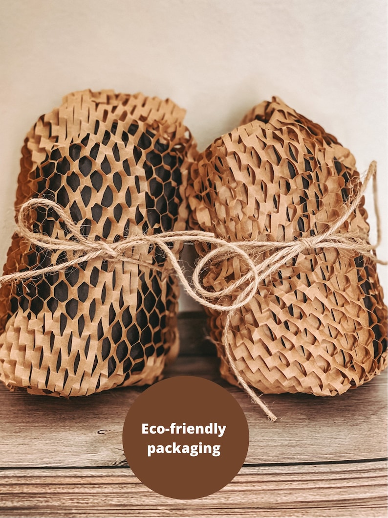 May include: Two items wrapped in brown paper honeycomb packaging tied with twine. The text "Eco-friendly packaging" is written in a brown circle.
