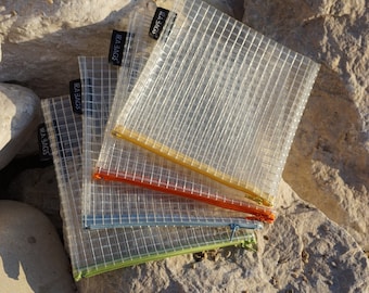 May include: Four clear plastic zippered pouches with different colored zippers. The pouches are stacked on top of each other and have the text "IRA BAGS" printed on the front.