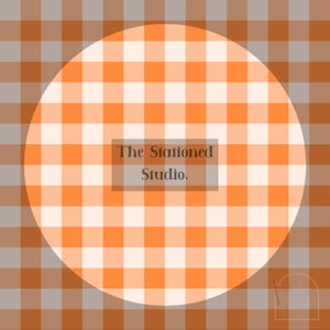 May include: A circular orange and white gingham pattern is set against a backdrop of a similar, but larger, pattern in shades of orange, grey, and brown. The text "The Stationed Studio." is centered within the circle.