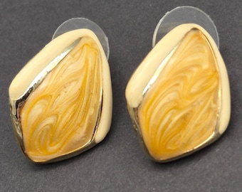 May include: A pair of gold and cream-colored earrings with a swirl pattern. The earrings are shaped like a teardrop.