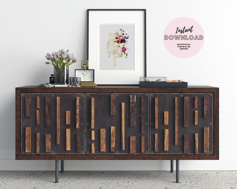 May include: A framed print of a floral anatomical heart illustration with a dark wood frame on a dark wood dresser with three drawers. The dresser has a geometric pattern of wood strips on the front. The dresser is sitting on a light gray floor. The print is on a light gray background. The flowers are in shades of pink, red, and purple. The heart is gold. The text "Instant Download" is on a pink circle.