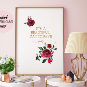 May include: A printable art print with a white background and gold text that reads "It's a beautiful day to save lives". The text is surrounded by a watercolour illustration of red and pink flowers.