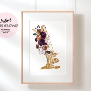 Pode incluir: Um microsc&oacute;pio dourado com um arranjo floral de flores bord&ocirc;, rosa e brancas. As flores est&atilde;o dispostas em torno da lente e do corpo do microsc&oacute;pio.