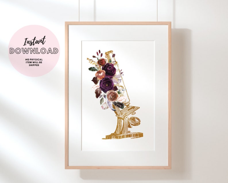 Pode incluir: Um microsc&oacute;pio dourado com um arranjo floral de flores bord&ocirc;, rosa e brancas. As flores est&atilde;o dispostas em torno da lente e do corpo do microsc&oacute;pio.