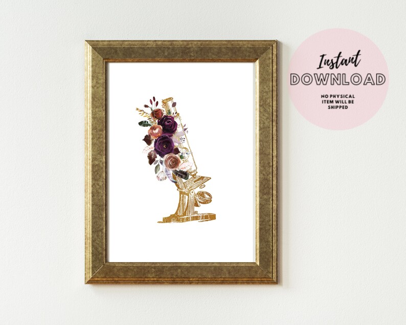Pode incluir: Um microsc&oacute;pio dourado com um arranjo floral de flores bord&ocirc;, rosa e brancas. As flores est&atilde;o dispostas ao redor da parte superior do microsc&oacute;pio.