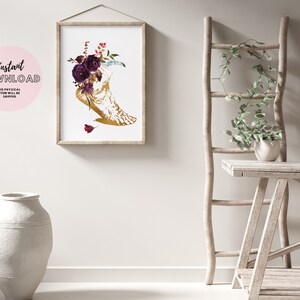 Pu&ograve; includere: Una stampa d'arte stampabile con una luna crescente dorata con un'arrangiamento floreale di rose bordeaux e foglie. La stampa &egrave; incorniciata e appesa a un muro bianco.