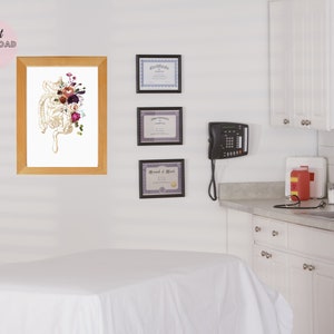 May include: A framed print of a medical illustration of the small intestine with a floral arrangement in shades of pink, purple, and white.