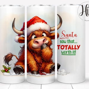 May include: A white tumbler featuring a cartoon Highland cow wearing a Santa hat and a red plaid scarf. The text "Santa saw that... TOTALLY worth it!" is printed on the side. The cow is brown with large horns.