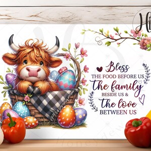 Op de afbeelding: Een wit snijplank met een schattige cartoon Highland koe die een mandje met kleurrijke paaseieren vasthoudt. De tekst op het snijplank luidt "Bless the food before us the family beside us & the love between us".
