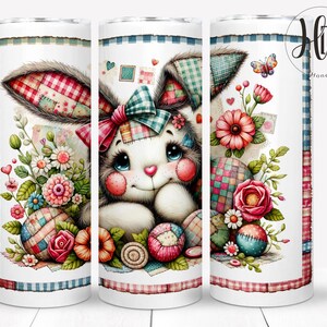 Pode incluir: Um copo branco com um design de coelho de retalhos. O coelho está rodeado de flores e ovos. O copo tem um padrão de xadrez azul e branco ao redor da parte superior e inferior.