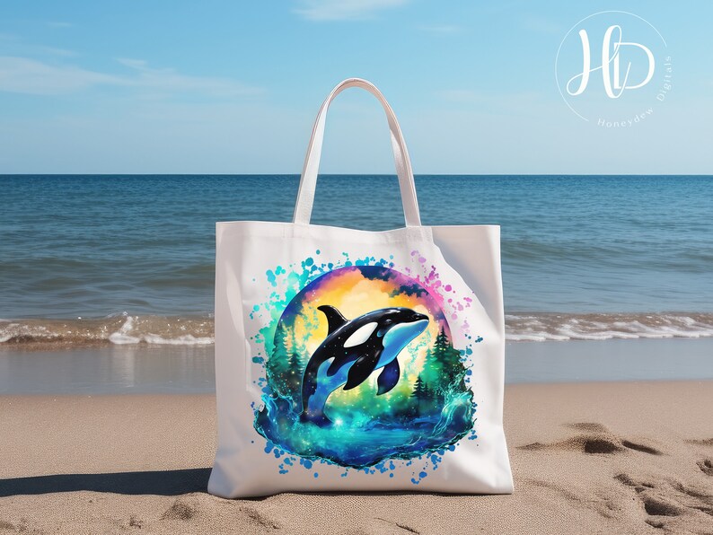 May include: White canvas tote bag with a colorful watercolor design of an orca jumping out of the water. The orca is black and white with a blue and green watercolor background.