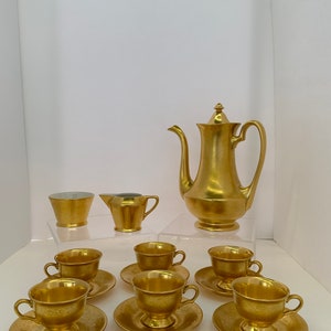May include: A gold-plated tea set with a teapot, creamer, sugar bowl, and six cups and saucers.