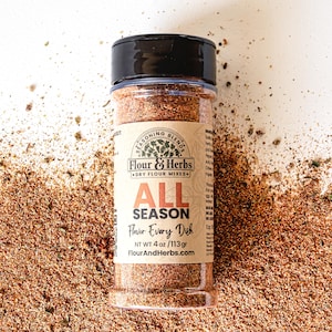 May include: A glass jar of brown all-purpose seasoning labeled "Flour & Herbs" with the text "All Season Flavor Every Dish" and "NT WT 4 oz/113gr FlourAndHerbs.com".