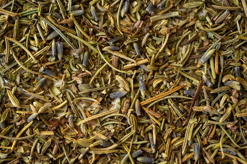 Pu&ograve; includere: Primo piano di un mix di erbe secche, tra cui rosmarino, timo e lavanda. Le erbe sono un mix di verde, marrone e viola.
