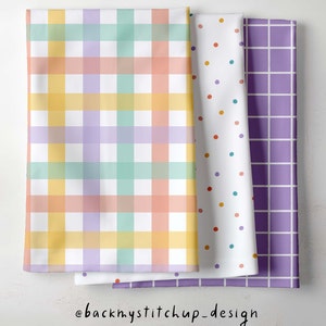 Könnte beinhalten: Drei gefaltete Stofftücher mit verschiedenen Mustern. Eines hat ein pastellfarbenes Karomuster in Gelb, Orange, Rosa, Grün und Lila. Ein anderes hat einen weißen Hintergrund mit bunten Punkten. Das dritte hat ein lila Gittermuster. Der Text "@backmystitchup_design" steht unten.