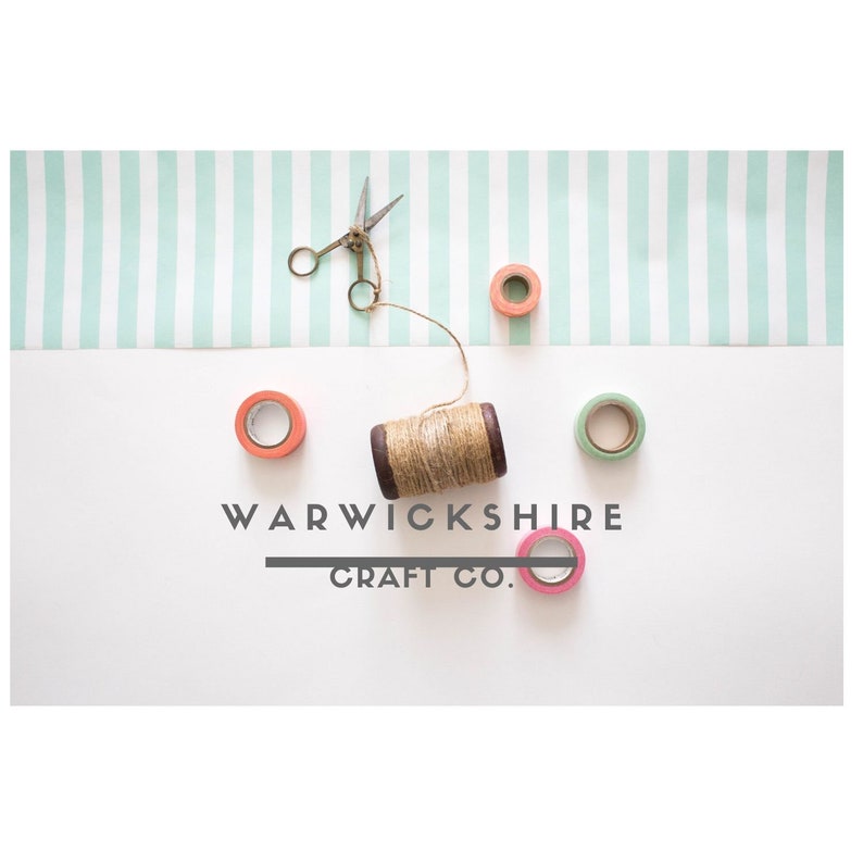 May include: A white background with a green and white striped paper strip at the top.  There are four rolls of washi tape in different colors, a spool of twine, and a pair of scissors. The text "WARWICKSHIRE CRAFT CO." is printed in black on the white background.