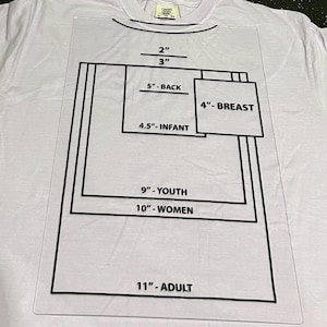May include: A white t-shirt with a clear plastic stencil overlay. The stencil has black lines and text indicating measurements for various sizes, including 2" and 3" for the neck, 5" for the back, and 4" for the breast. Other sizes include infant, youth, women, and adult.