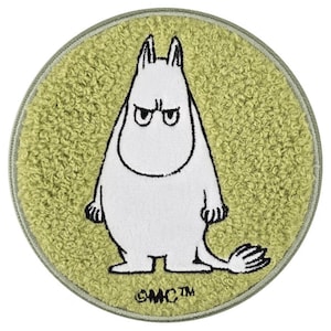 May include: A circular patch with a textured, light green, fuzzy surface featuring a white, cartoon-style character with black outlines and a stern expression. The character has a rounded body, pointed ears, and a tail. The text MC is printed in black.