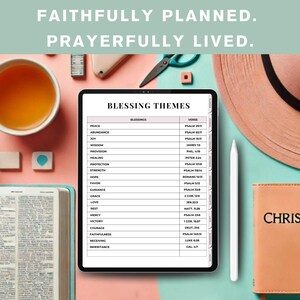 May include: A digital tablet displaying a list of blessings and corresponding Bible verses. The tablet is on a pink surface with a cup of tea, a potted plant, a small notebook, and a pair of scissors. The text on the tablet reads "Blessing Themes" and includes verses from the Bible.