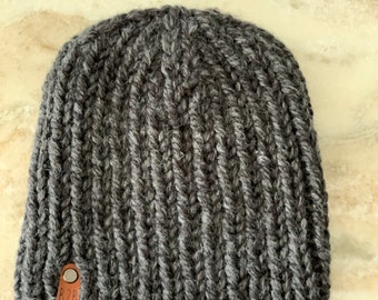 May include: A dark gray knitted beanie with a brown leather tag that says "B2B".