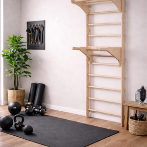Può includere: Un allestimento di palestra domestica con una scala da arrampicata in legno a parete, un tappetino per esercizi nero e vari pesi, tra cui kettlebell e palle mediche. Una pianta in vaso e un tavolino in legno completano lo spazio fitness.