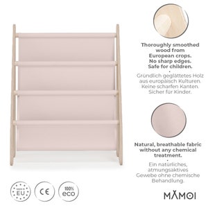 K&ouml;nnte beinhalten: Ein rosa Stoff-Regal mit vier Regalbrettern und einem naturbelassenen Holzrahmen. Das Regal ist aus europ&auml;ischem Holz gefertigt und f&uuml;r Kinder sicher. Der Stoff ist atmungsaktiv und chemiefrei. Der Text auf dem Bild lautet "Thoroughly smoothed wood from European crops. No sharp edges. Safe for children." und "Natural, breathable fabric without any chemical treatment. Ein nat&uuml;rliches, atmungsaktives Gewebe ohne chemische Behandlung."