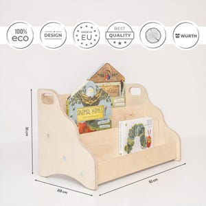 May include: A light-colored wooden bookshelf with two tiers and side handles, measuring 31 cm in height, 51 cm in width, and 28 cm in depth. The shelf holds two children's books, one titled Animal Homes and the other The Very Hungry Caterpillar.