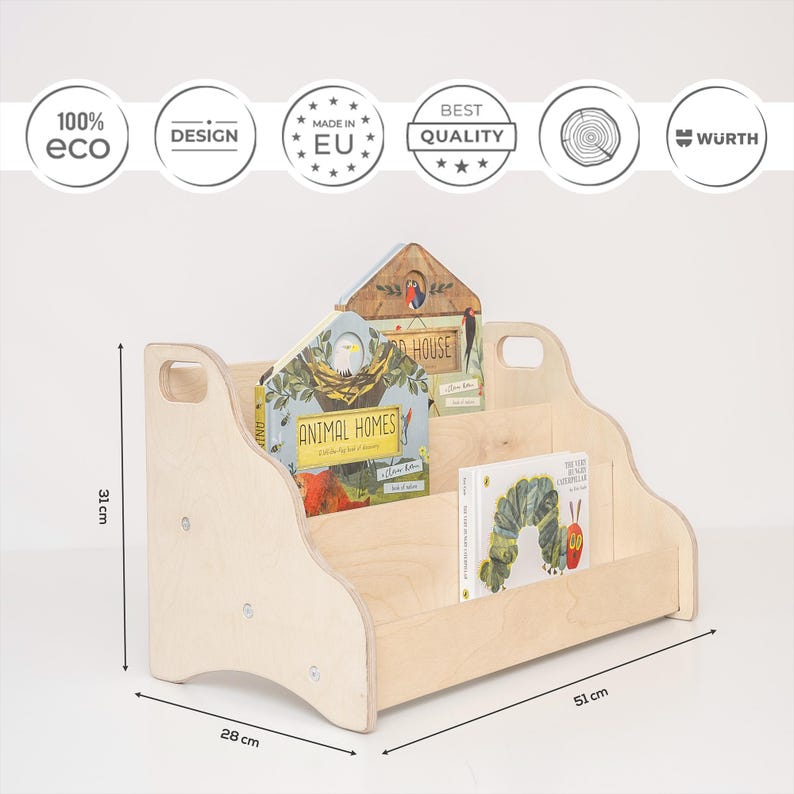 May include: A light-colored wooden bookshelf with two tiers and side handles, measuring 31 cm in height, 51 cm in width, and 28 cm in depth. The shelf holds two children's books, one titled Animal Homes and the other The Very Hungry Caterpillar.