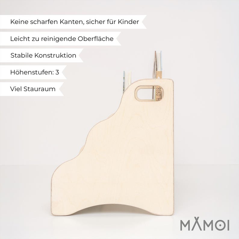 May include: A light-colored wooden bookshelf with a stepped design featuring three distinct height levels for storage. The side panel includes a cutout handle for portability. The text on the image reads: Keine scharfen Kanten, sicher f&uuml;r Kinder, Leicht zu reinigende Oberfl&auml;che, Stabile Konstruktion, H&ouml;henstufen: 3, Viel Stauraum.