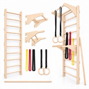 Può includere: Un set di spalliera svedese in legno chiaro da parete, completo di barra per trazioni, due supporti in legno rimovibili, due paia di anelli da ginnastica con cinghie nere e tre bande di resistenza nei colori giallo, rosso e nero.