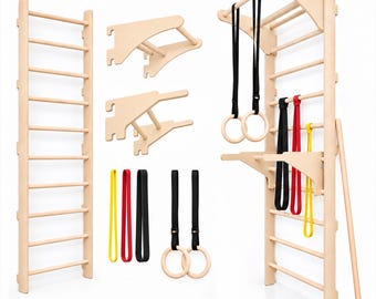 Può includere: Un set di spalliera svedese in legno chiaro da parete, completo di barra per trazioni, due supporti in legno rimovibili, due paia di anelli da ginnastica con cinghie nere e tre bande di resistenza nei colori giallo, rosso e nero.