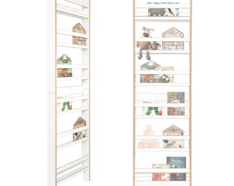 Può includere: Libreria in legno bianco con più ripiani, contenente libri e giocattoli per bambini. La libreria ha un design a scala con un bordo in legno naturale. Alcuni libri hanno il testo "Where's" visibile. I ripiani sono pieni di libri colorati e piccoli giocattoli.