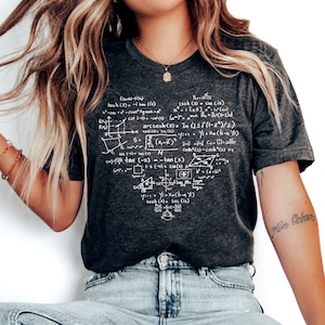 May include: A dark grey t-shirt with a white graphic print of mathematical equations and formulas. The shirt has a crew neck and short sleeves.