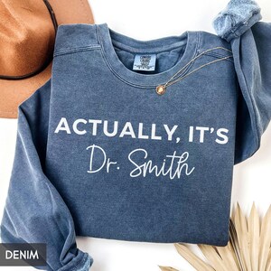 Comfort Colors® Funny New Doctor Graduation Sweatshirt with Custom name, Actually its Doctor, Personalized PHD Hoodie, Doctorate PHD MD Grad